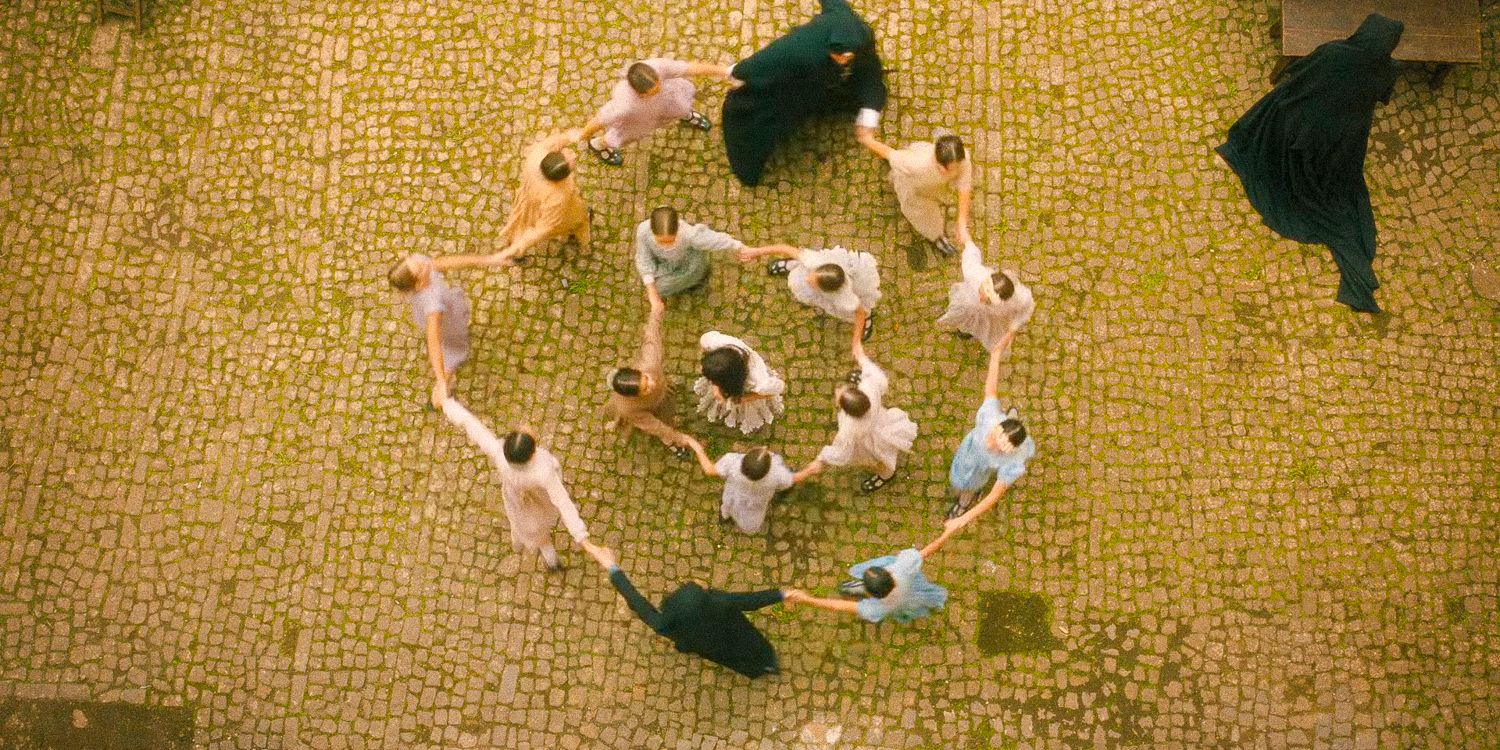 An aerial shot of the orphanage girls playing, forming a circle around Carlita in The First Omen
