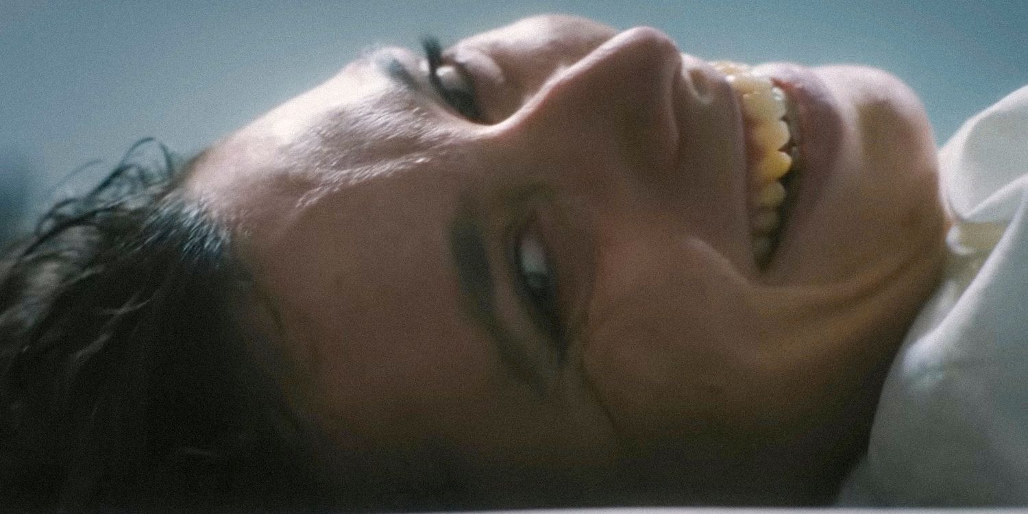 Close-up shot of the pregnant woman's face with a look of madness in the first omen